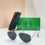 Silver-tone sunglasses with dark blue-tinted lenses on a display stand