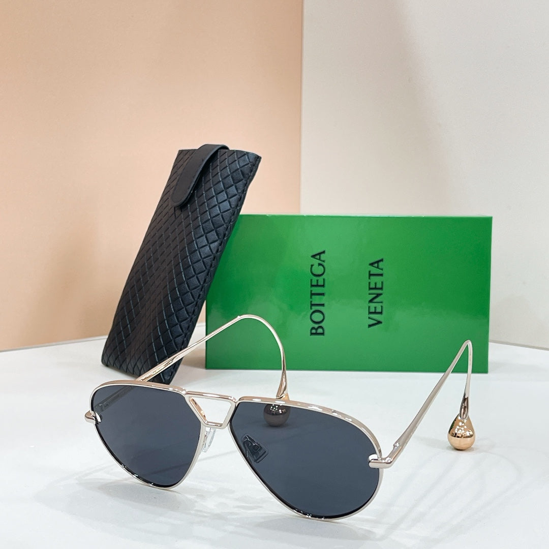 Silver-tone sunglasses with dark blue-tinted lenses on a display stand