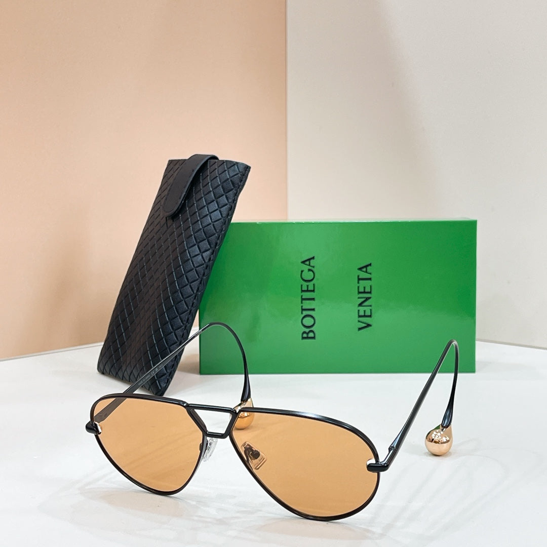 Black sunglasses with amber-tinted lenses on a display stand