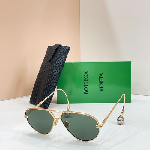 Gold-tone aviator sunglasses with dark lenses, thin metal bridge, and black top case