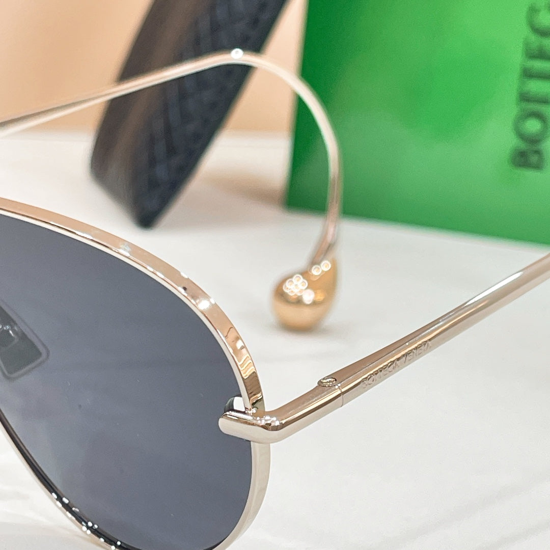 Aviator sunglasses side close-up with gold-tone bridge and dark lens edge
