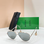 Gold-tone aviator sunglasses with light-reflective dark lenses and curved metal temples