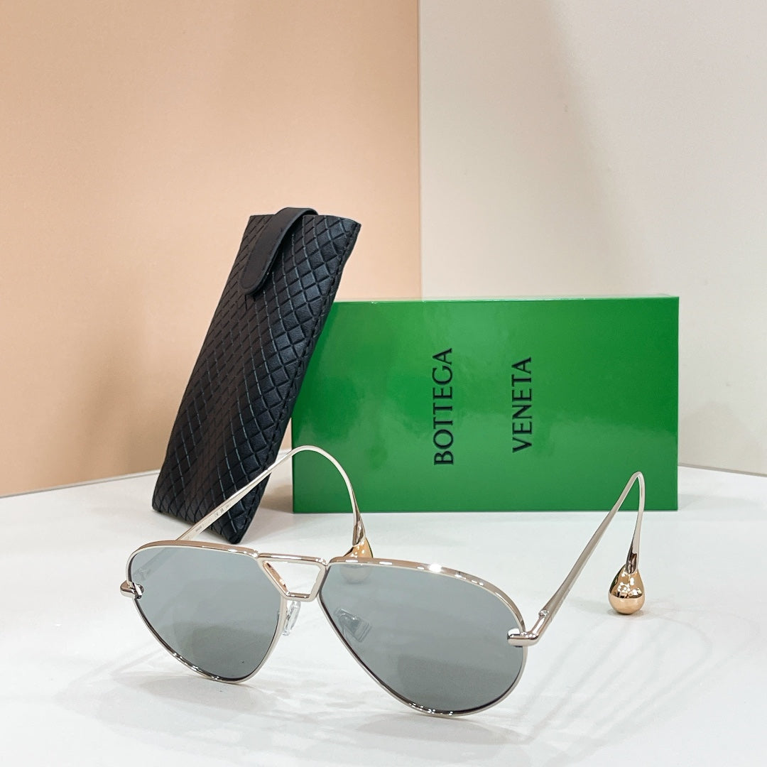 Gold-tone aviator sunglasses with light-reflective dark lenses and curved metal temples
