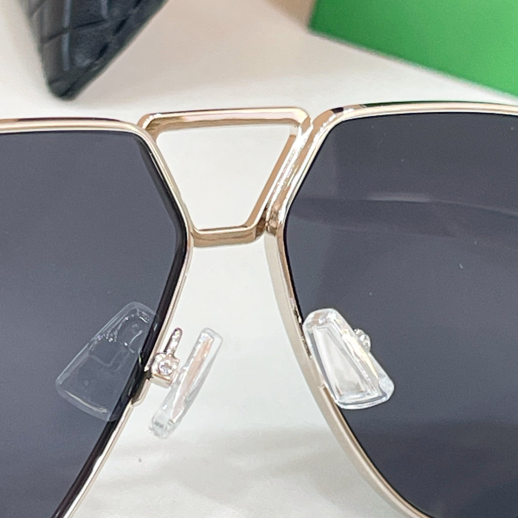 Aviator sunglasses close-up of gold-tone frame and dark lenses with hinged detail