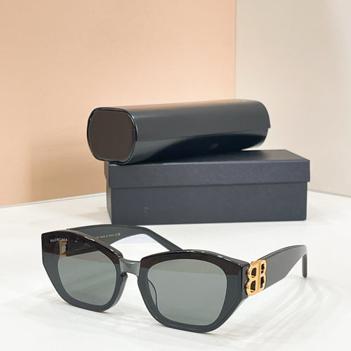 Dark cat-eye sunglasses with green-tinted lenses and gold-tone B logo on the temple
