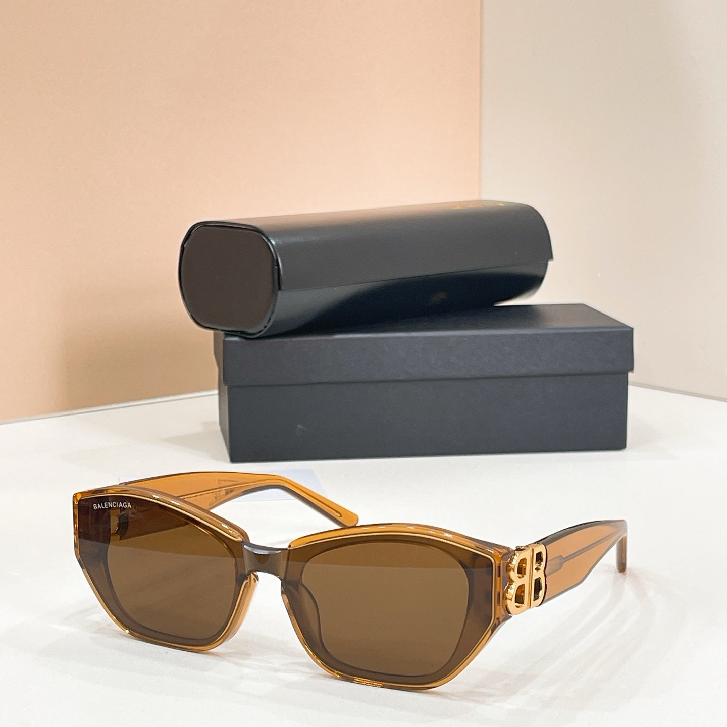 Amber cat-eye sunglasses with brown-tinted lenses and gold-tone B logo on the temple