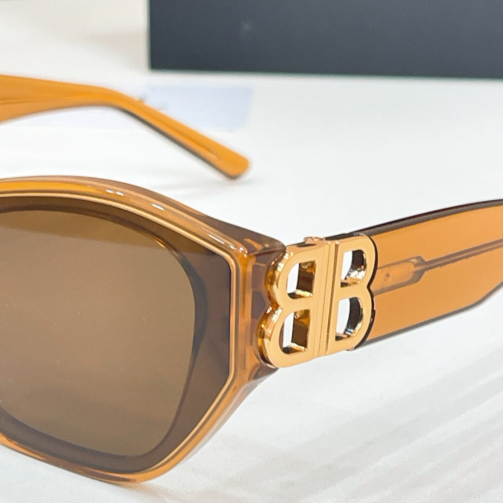 Amber cat-eye sunglasses close-up of gold-tone B logo on the temple and metal arm