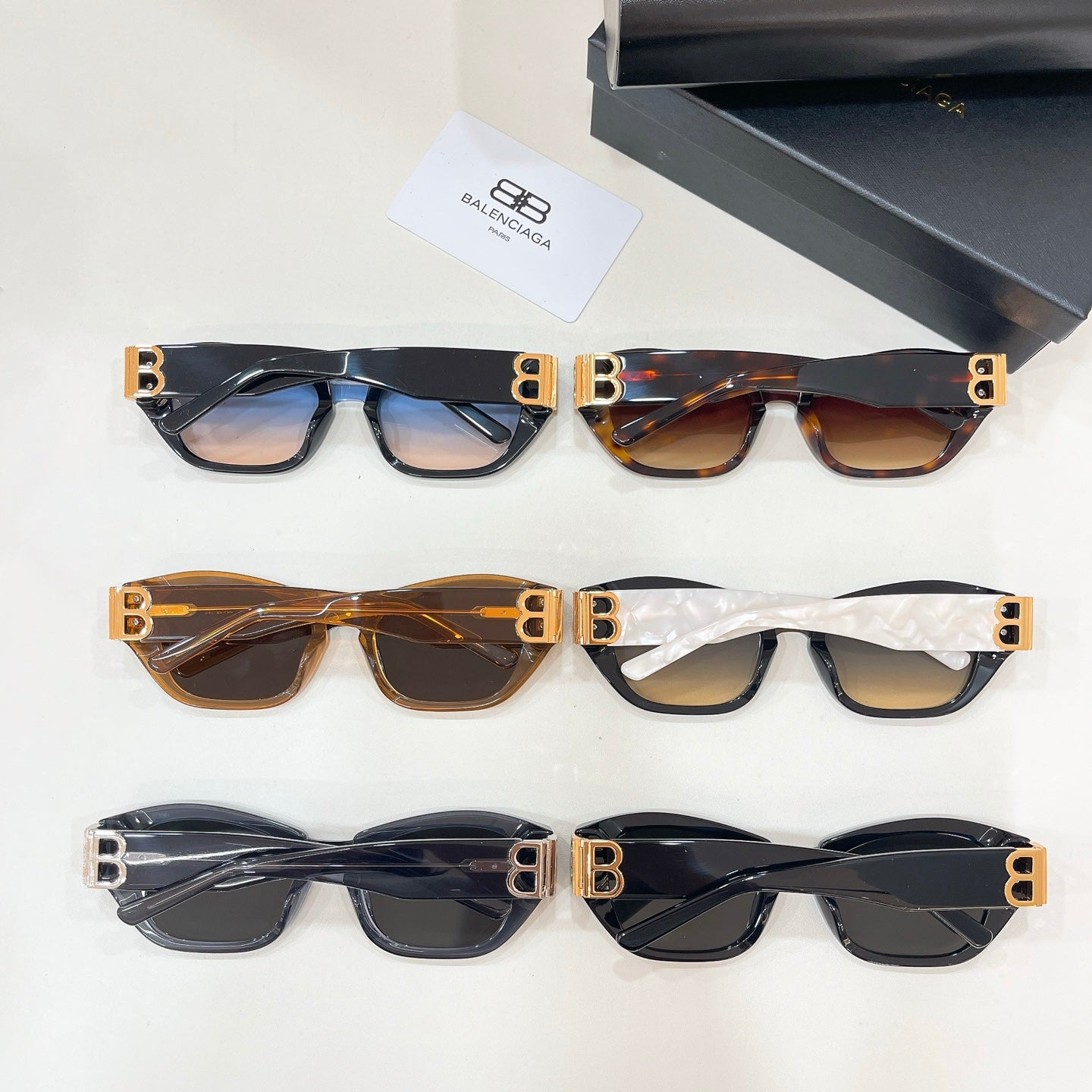 Multiple cat-eye sunglasses laid out with gold-tone B logos in black and tortoise frames