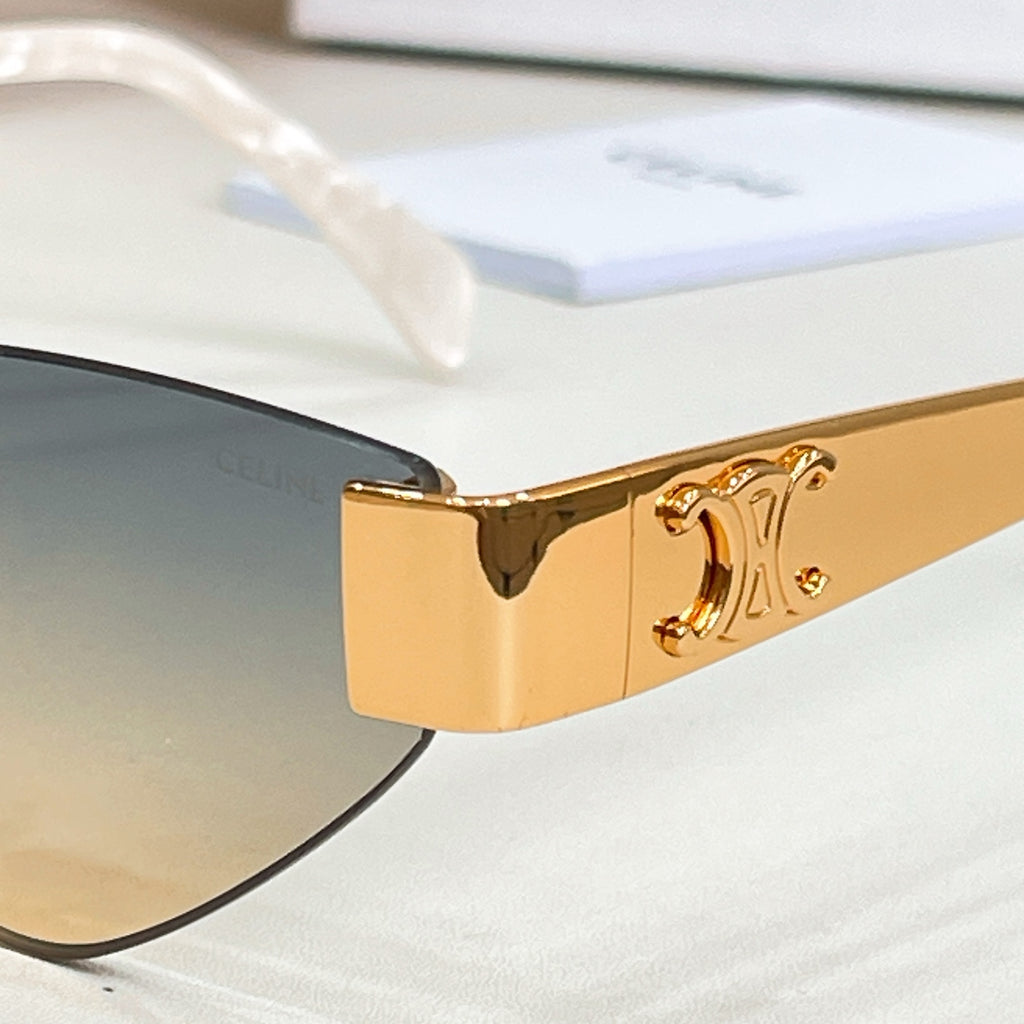 Close-up of gold-tone cat-eye sunglasses frame and hinge detail