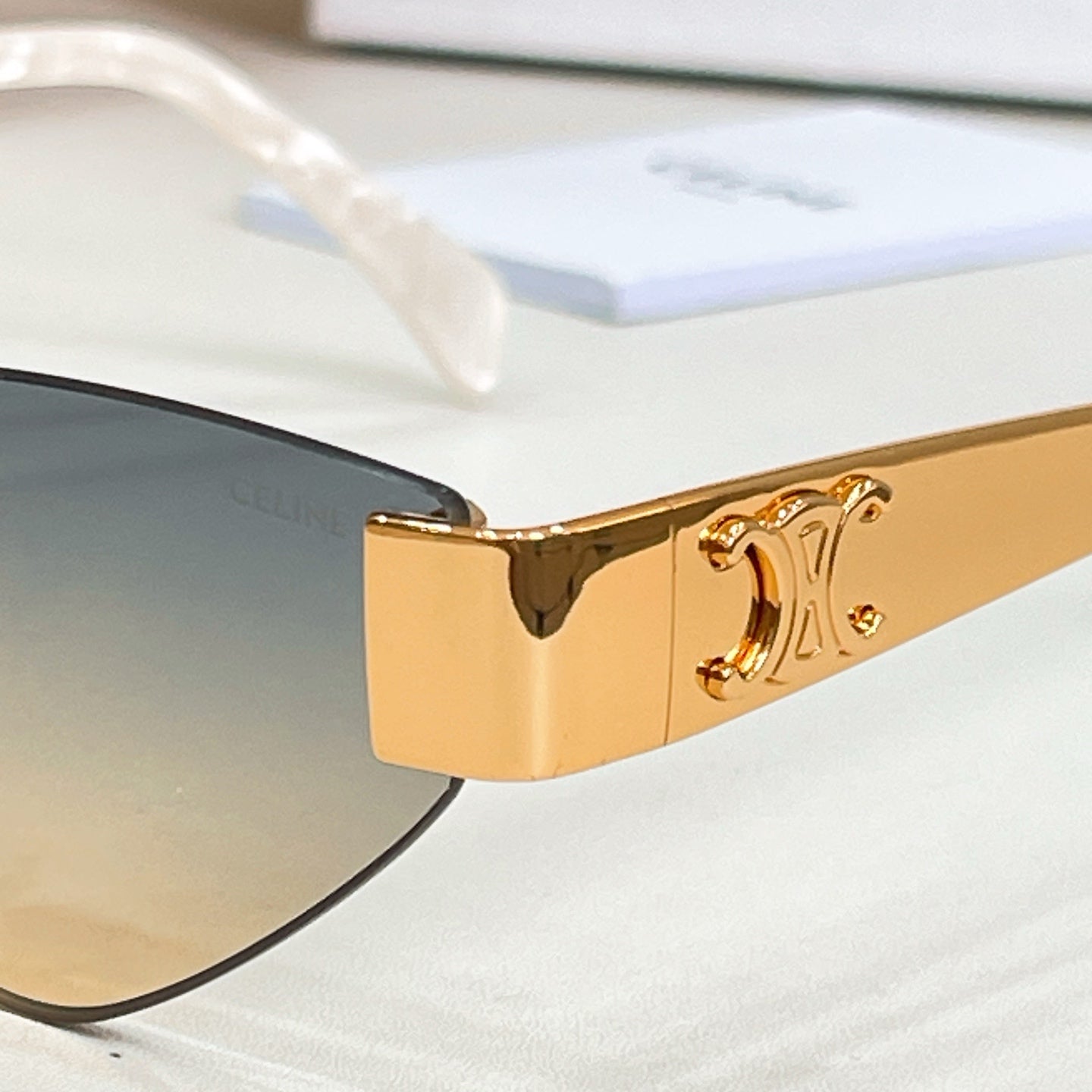 Close-up of gold-tone cat-eye sunglasses frame and hinge detail