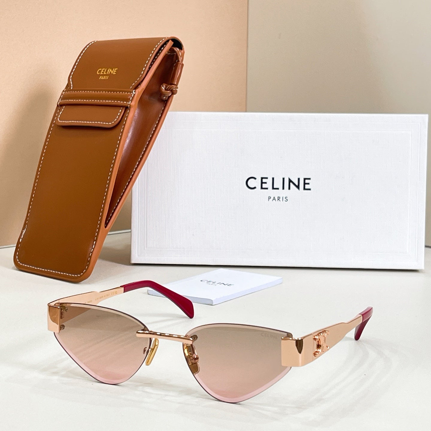 Cat-eye sunglasses with blush-pink temples and gold-tone frame, tinted lenses