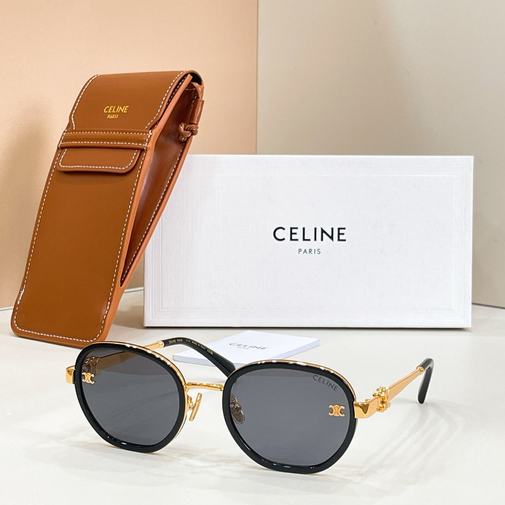 Round sunglasses with dark lenses, gold-tone frame accents, and temple logo emblem