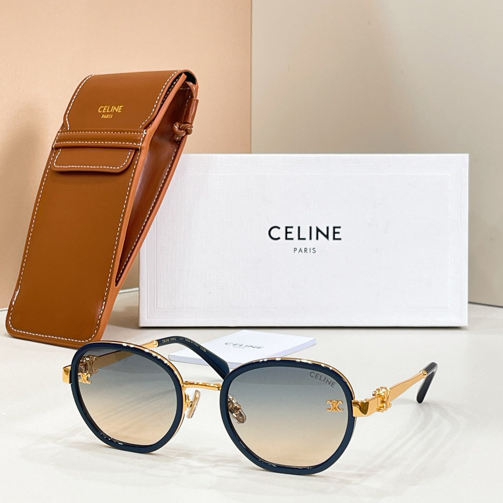 Round sunglasses with blue-tinted lenses, dark frame, and gold-tone temple logo emblem