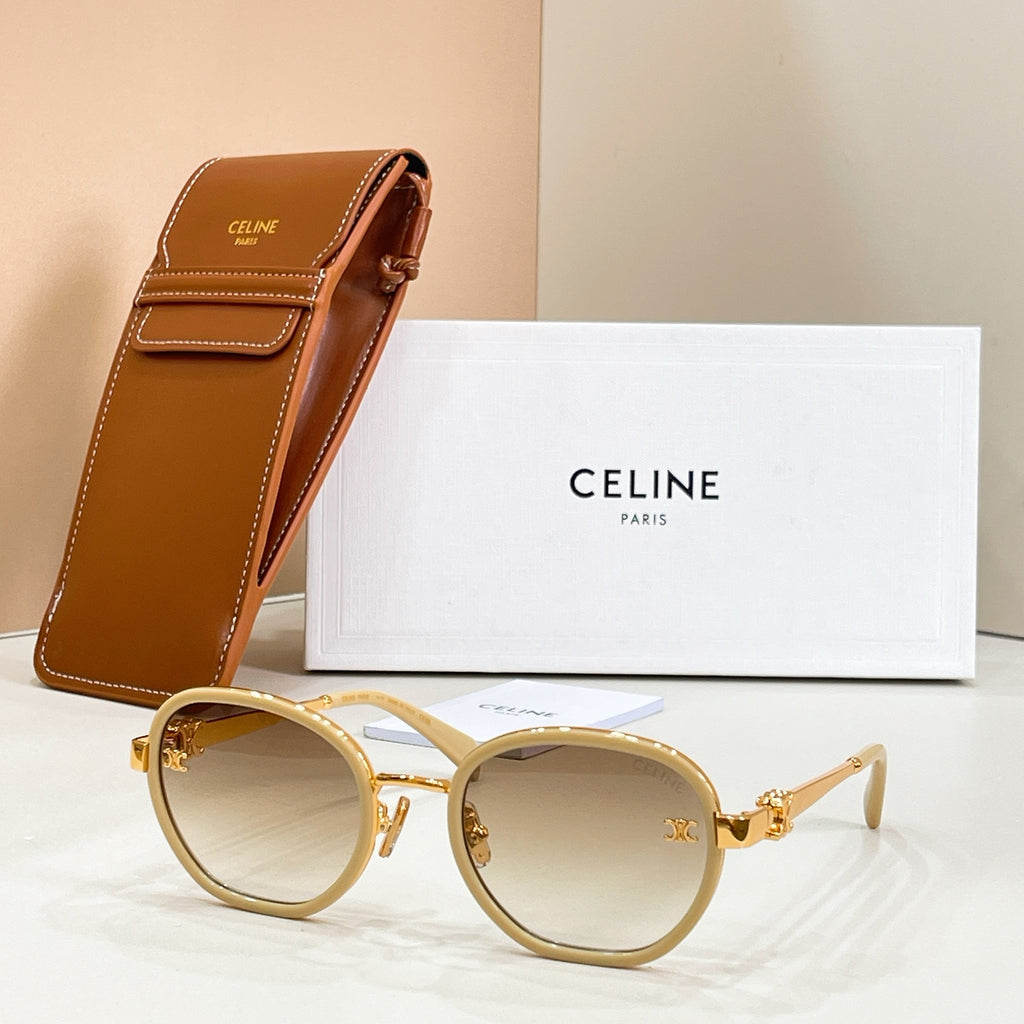 Round sunglasses with light-tinted lenses, gold-tone frame, and temple logo emblem