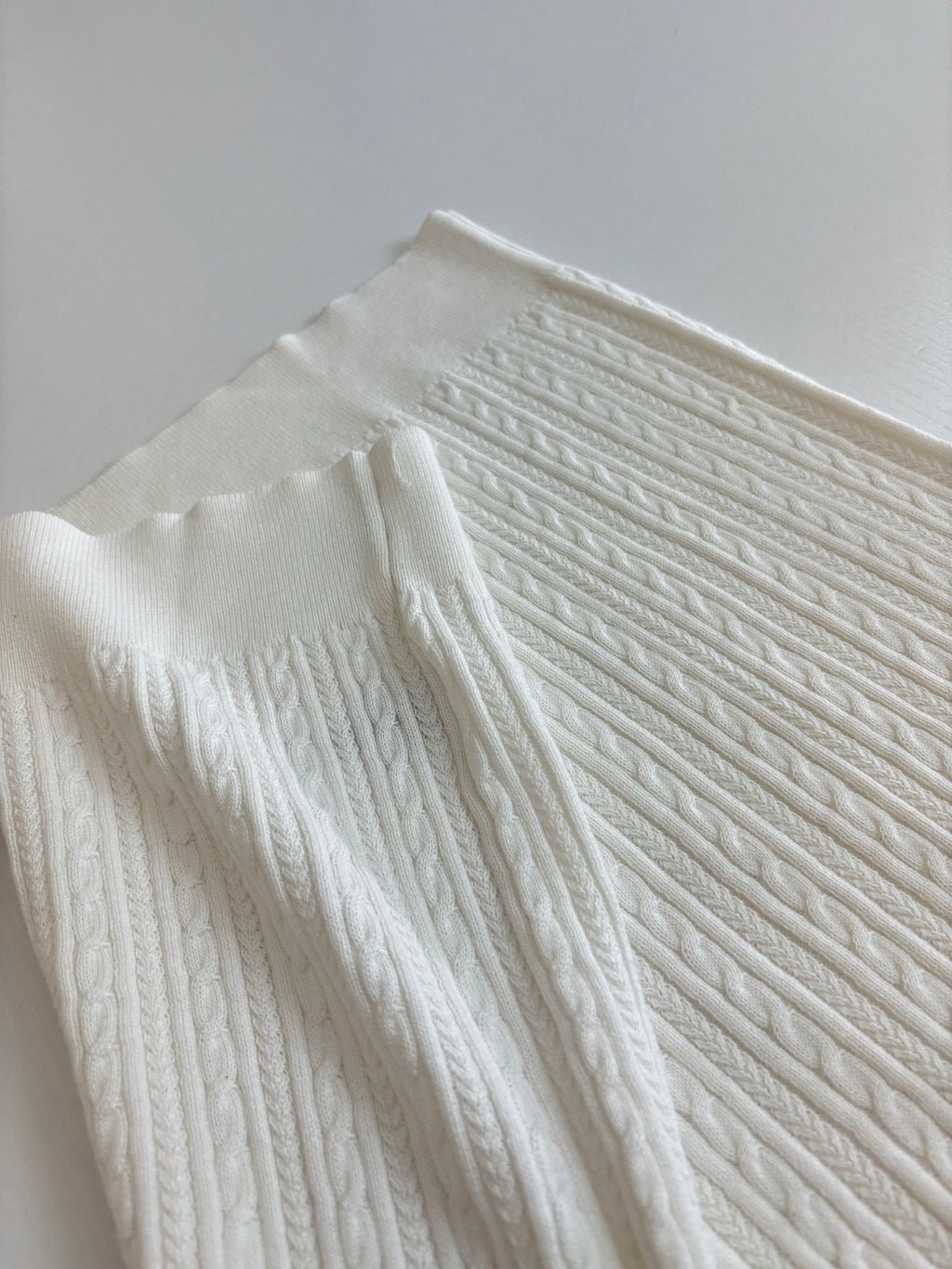 White cable-knit polo shirt textured fabric and shoulder seam