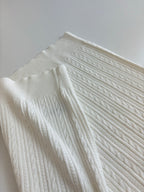 White cable-knit polo shirt textured fabric and shoulder seam
