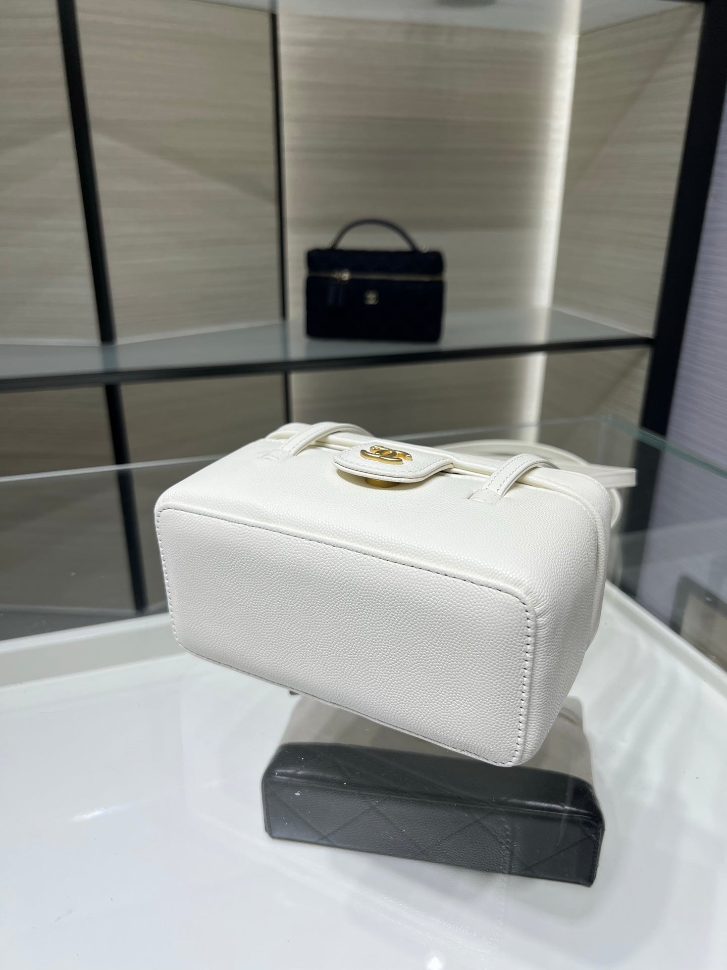White Chanel mini handbag with gold clasp hardware and structured shape