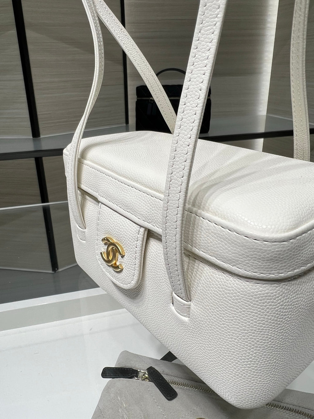 White Chanel handbag with textured leather, top handle, and CC emblem