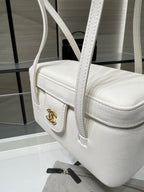White Chanel handbag with textured leather, top handle, and CC emblem