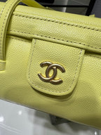 Yellow leather bag corner with gold Chanel logo emblem and stitching