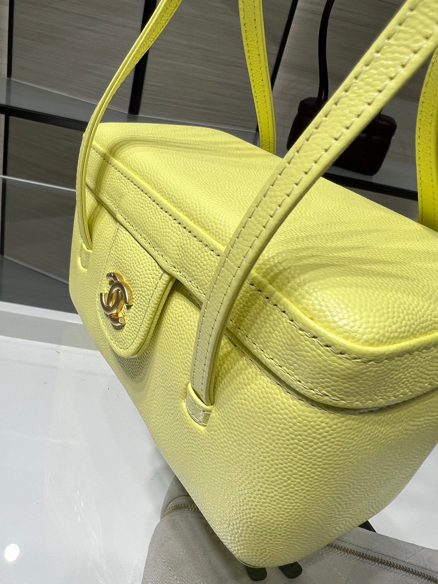 Yellow leather mini handbag with curved top handle and front logo detail