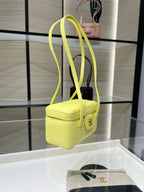 Yellow mini handbag with long shoulder strap and front flap clasp