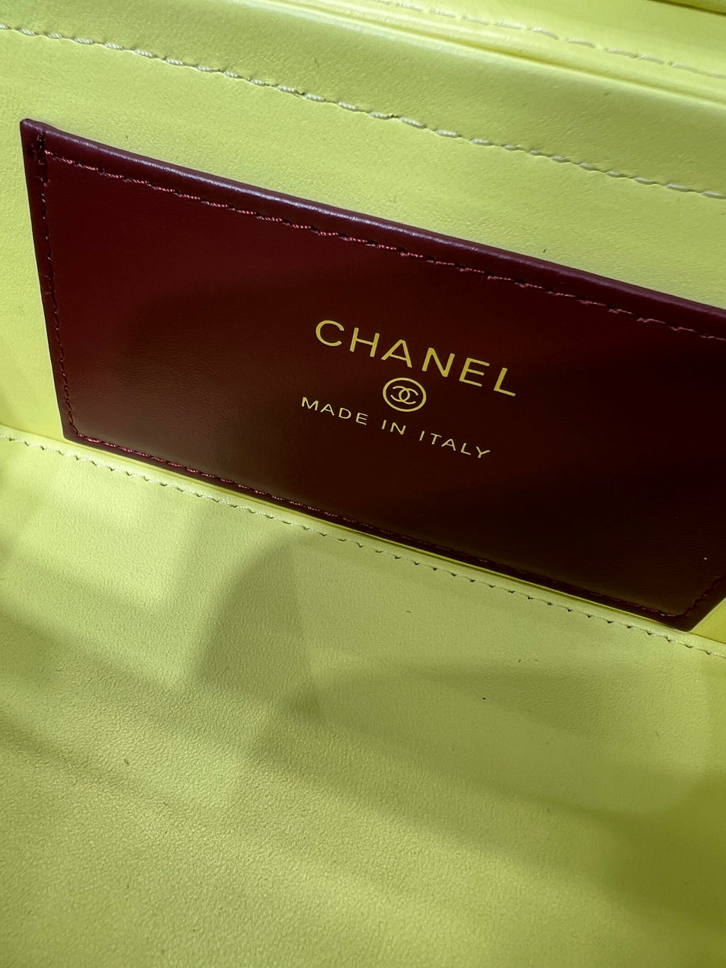 Yellow handbag interior label reading CHANEL MADE IN ITALY