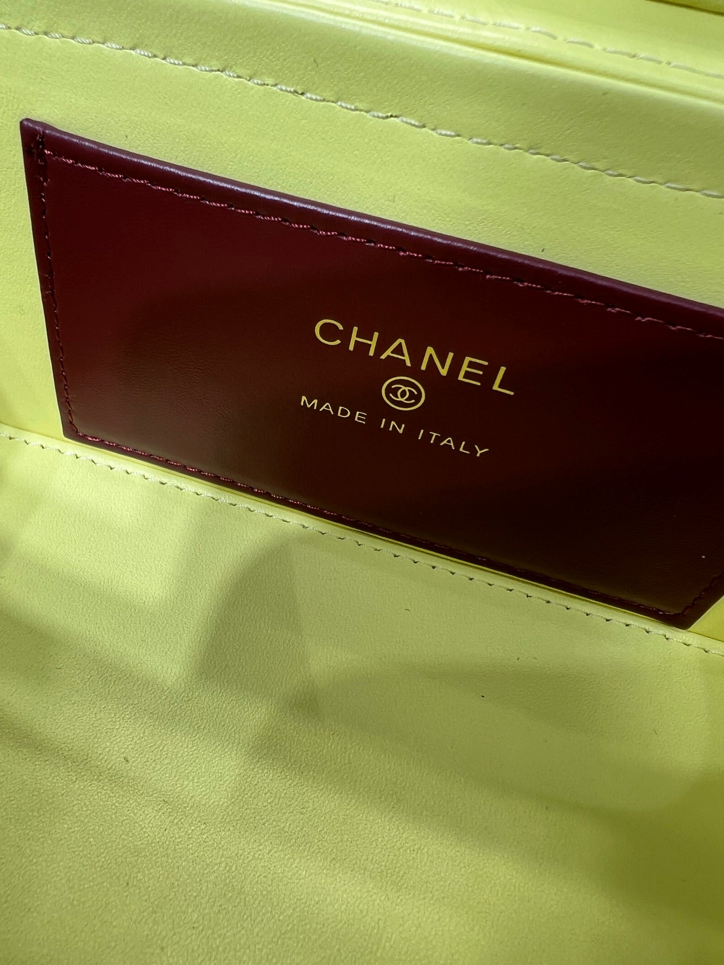Yellow handbag interior label reading CHANEL MADE IN ITALY