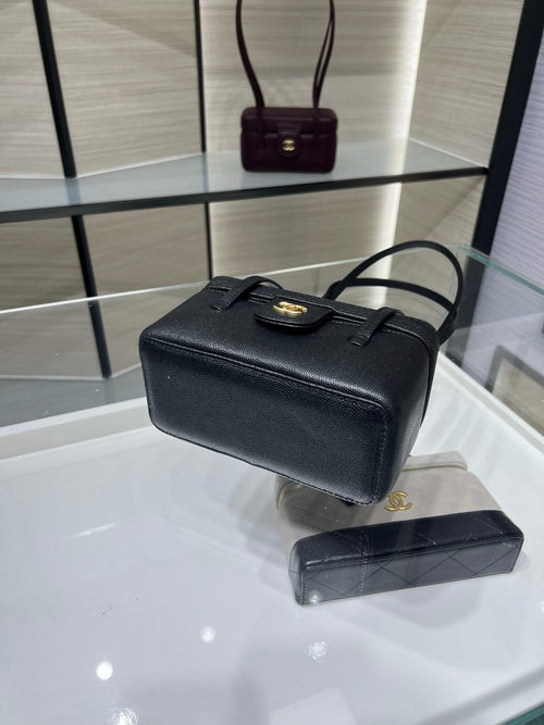 Black Chanel structured bag with gold CC emblem, front flap and detachable strap.
