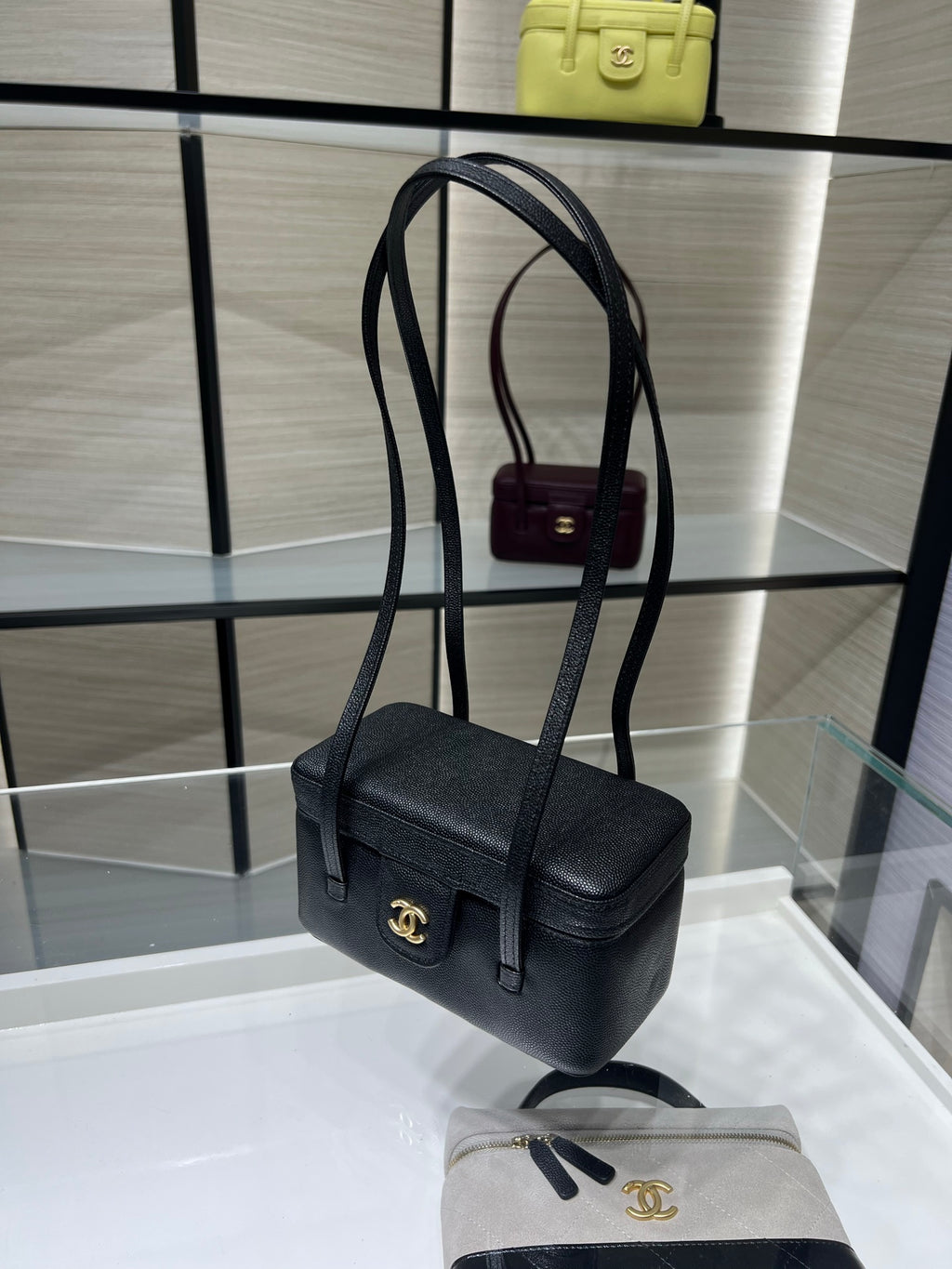 Black Chanel mini shoulder bag with gold CC emblem, adjustable strap and front flap.