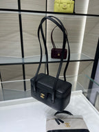 Black Chanel mini shoulder bag with gold CC emblem, adjustable strap and front flap.
