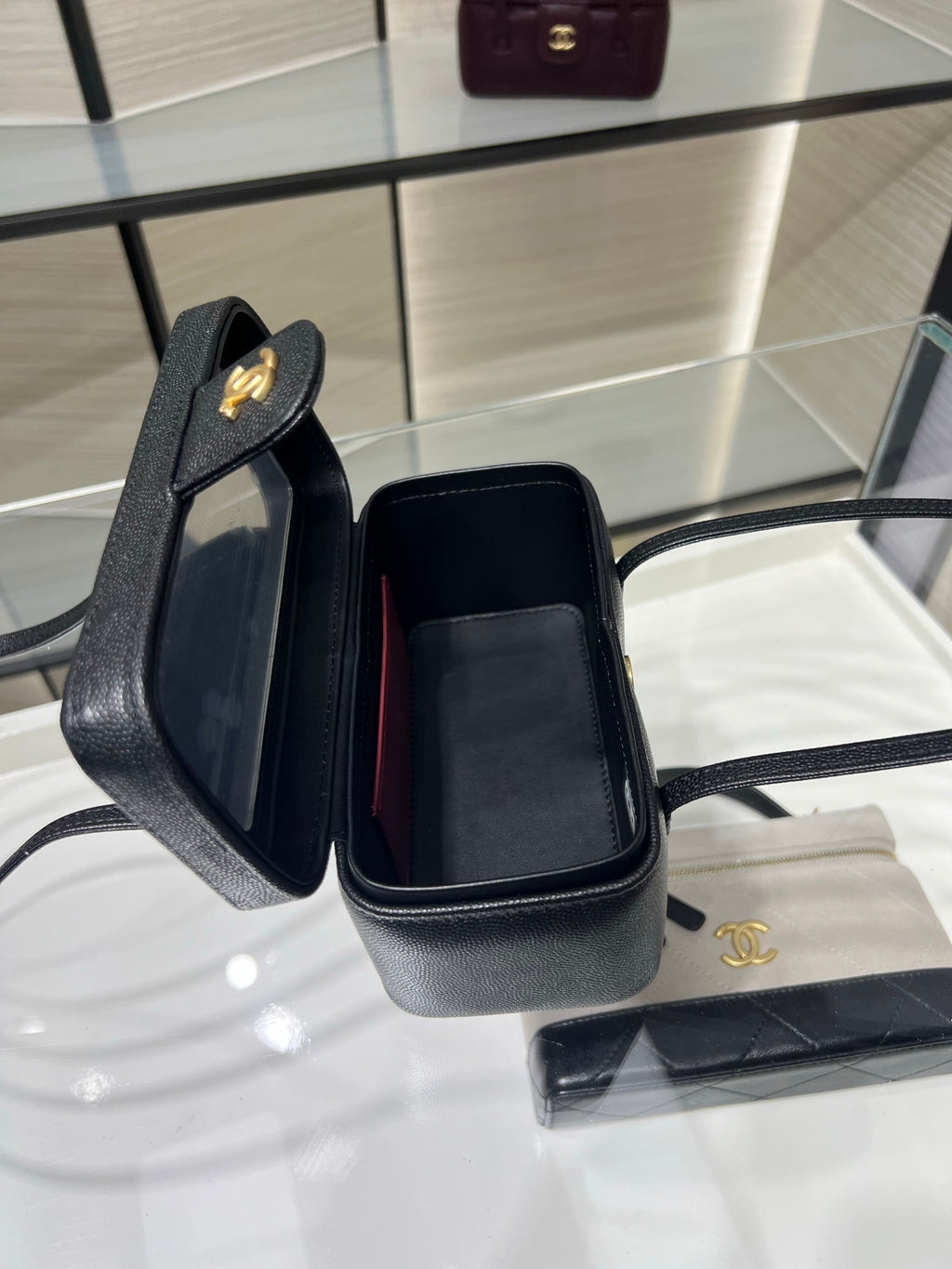 Black Chanel bag open view with fabric-lined interior and gold CC logo on flap.