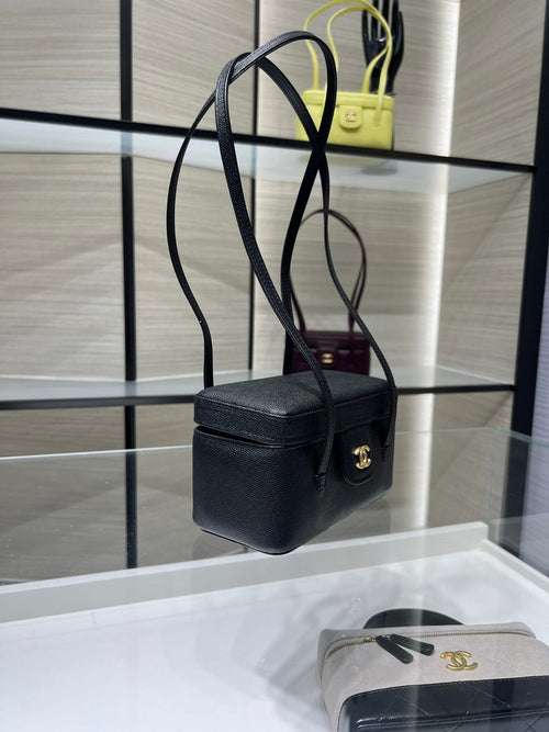 Black Chanel mini shoulder bag with gold CC clasp and top handle, textured leather.
