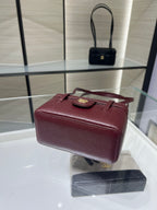 Burgundy Chanel handbag with short handles and gold front logo, top flap