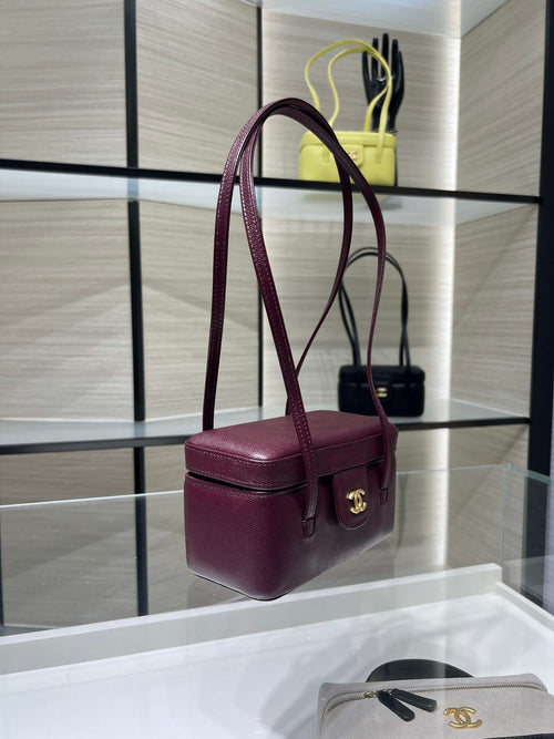 Burgundy Chanel bag with gold CC clasp and top handle, structured mini shape