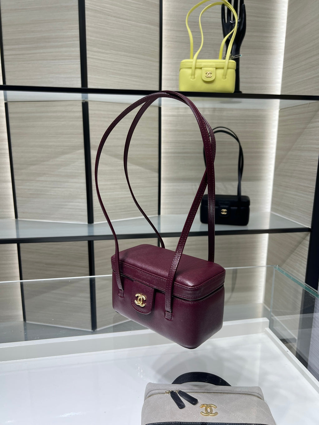 Burgundy Chanel shoulder bag with gold CC clasp and twin top handles, side view