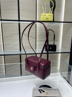 Burgundy Chanel shoulder bag with gold CC clasp and twin top handles, side view