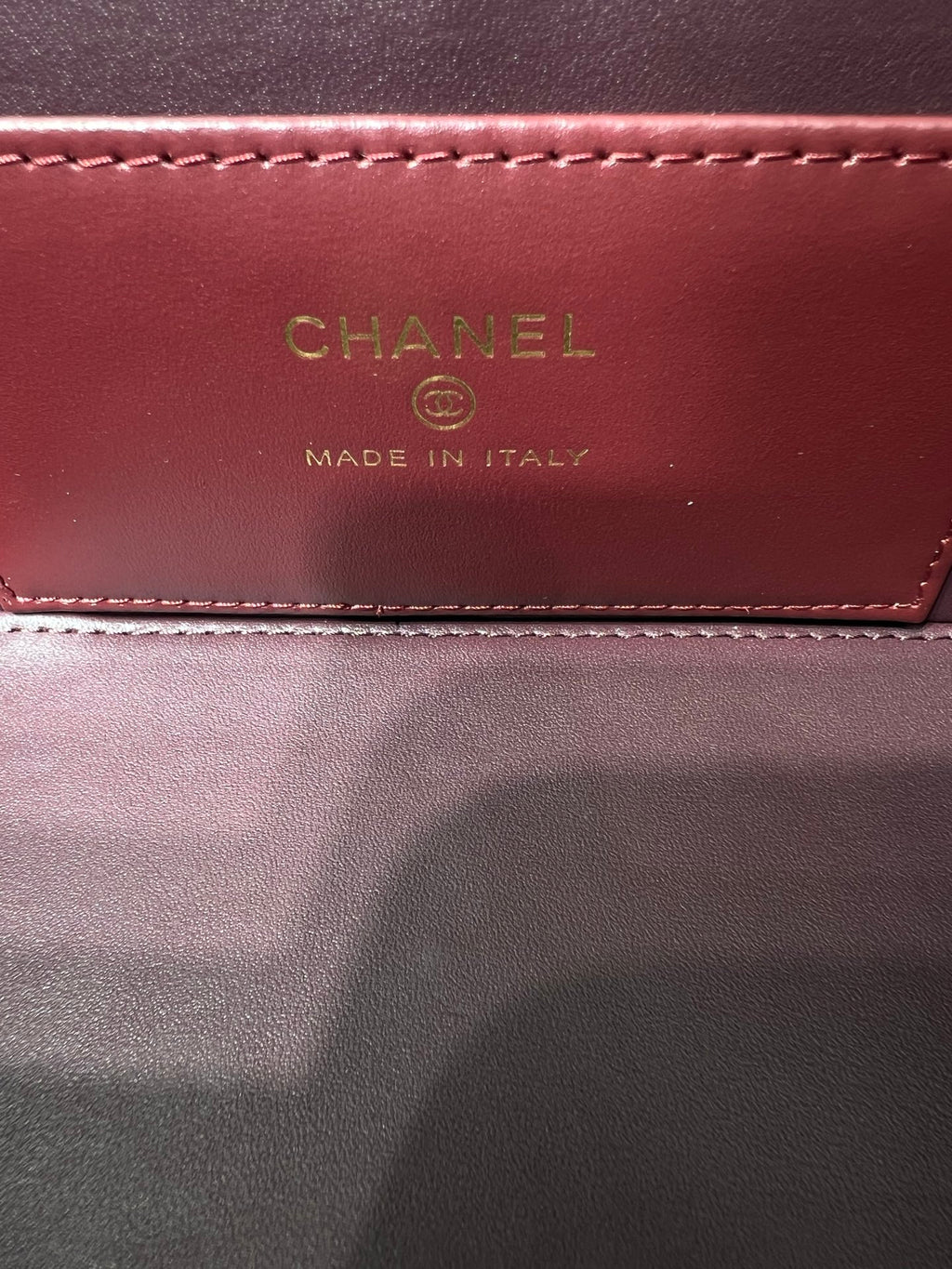Chanel bag interior label reading CHANEL and MADE IN ITALY on burgundy lining