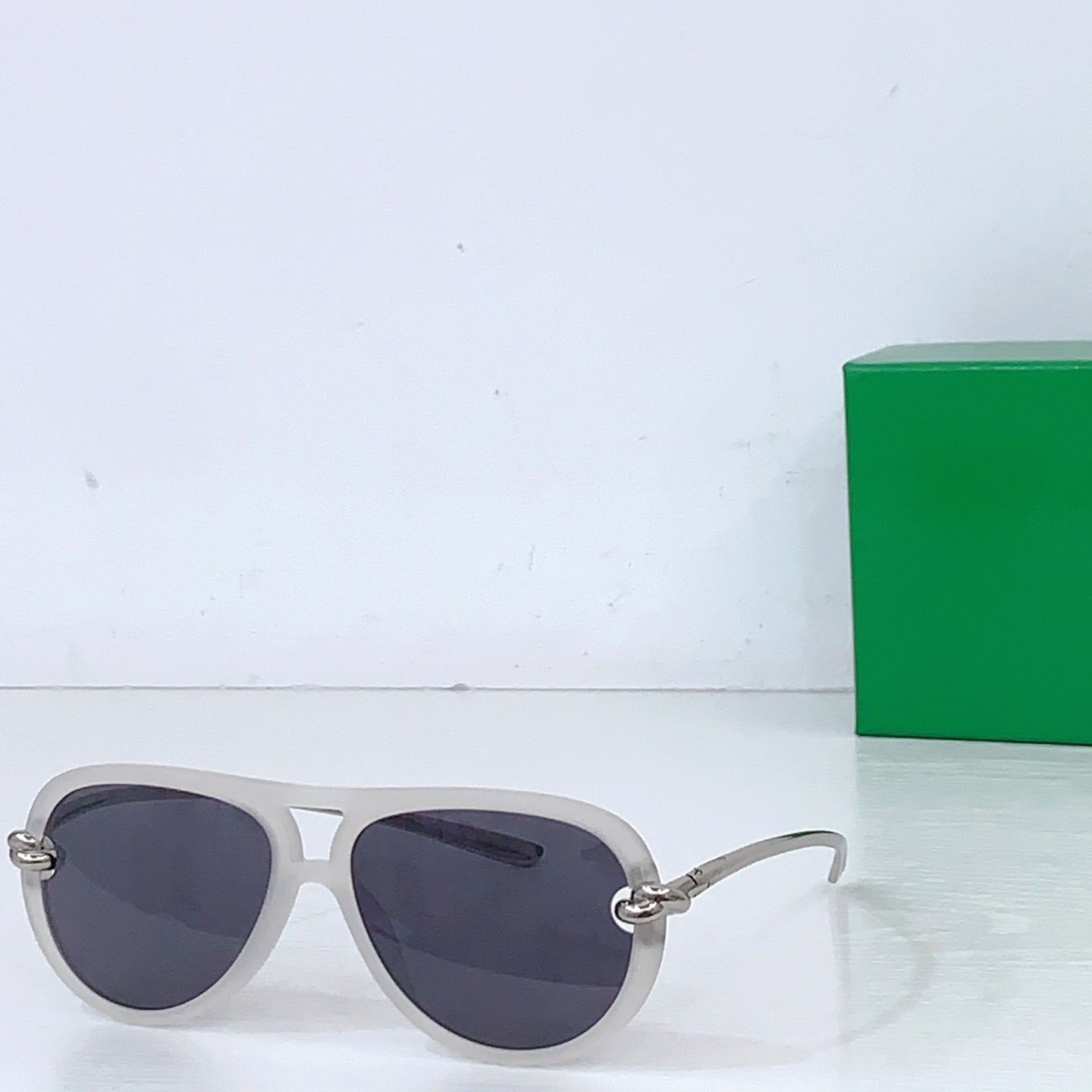 Bottega Veneta sunglasses, light gray frames with dark lenses and gold-tone hinges