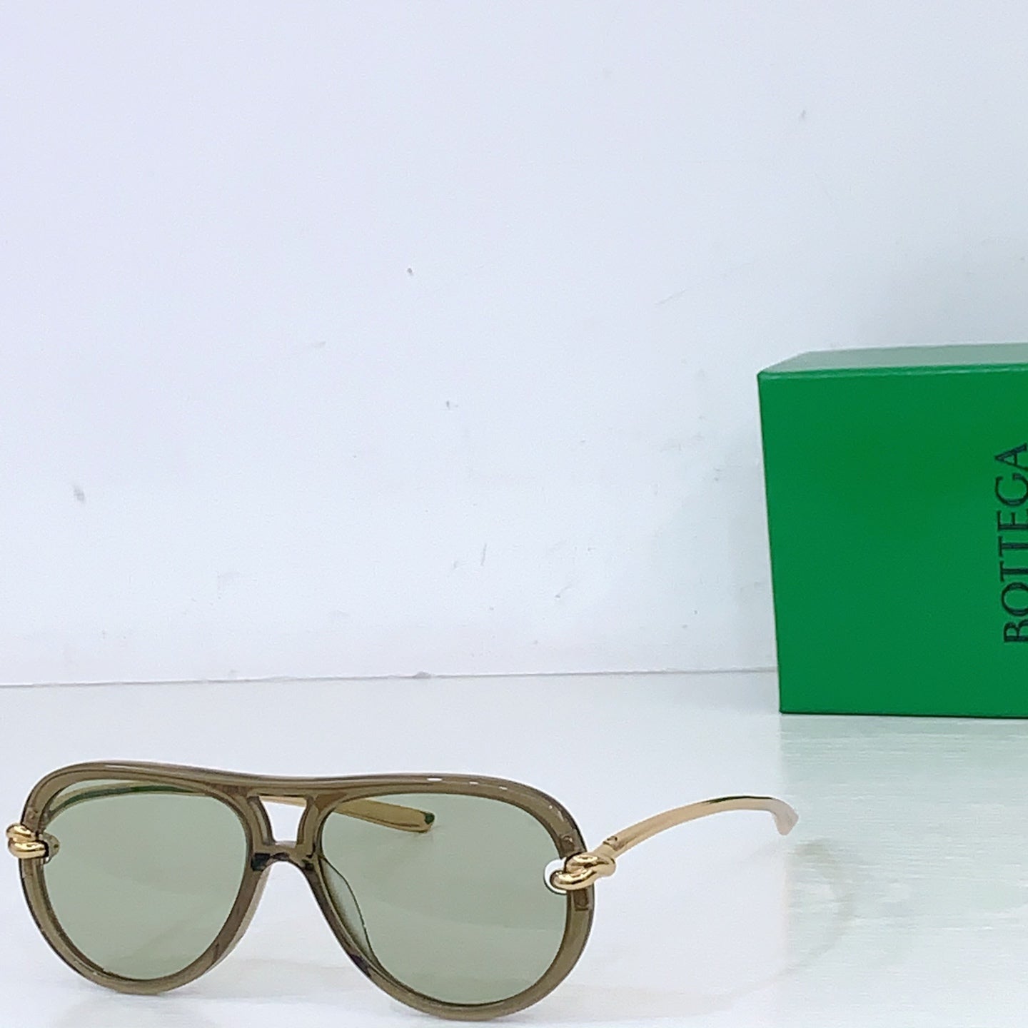 Bottega Veneta sunglasses, olive green frames with light green lenses and gold-tone hinges