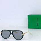 Bottega Veneta sunglasses with dark green frames, clear lenses, and gold-tone metal arms