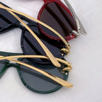 Bottega Veneta sunglasses layered together: black pair and green pair with gold temples