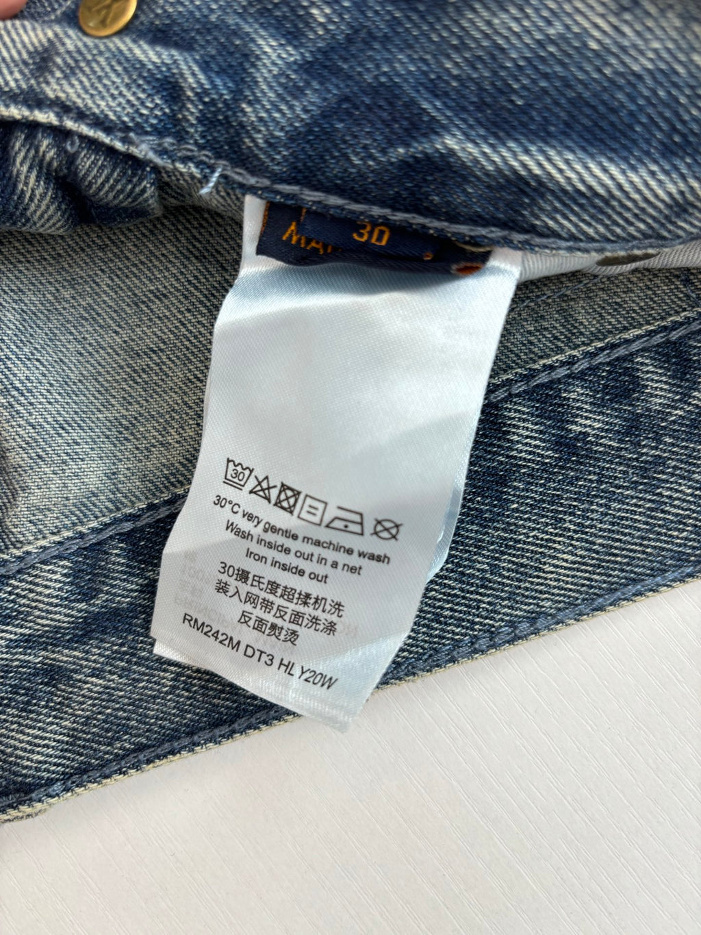 Denim pants care label inside waistband with washing instructions
