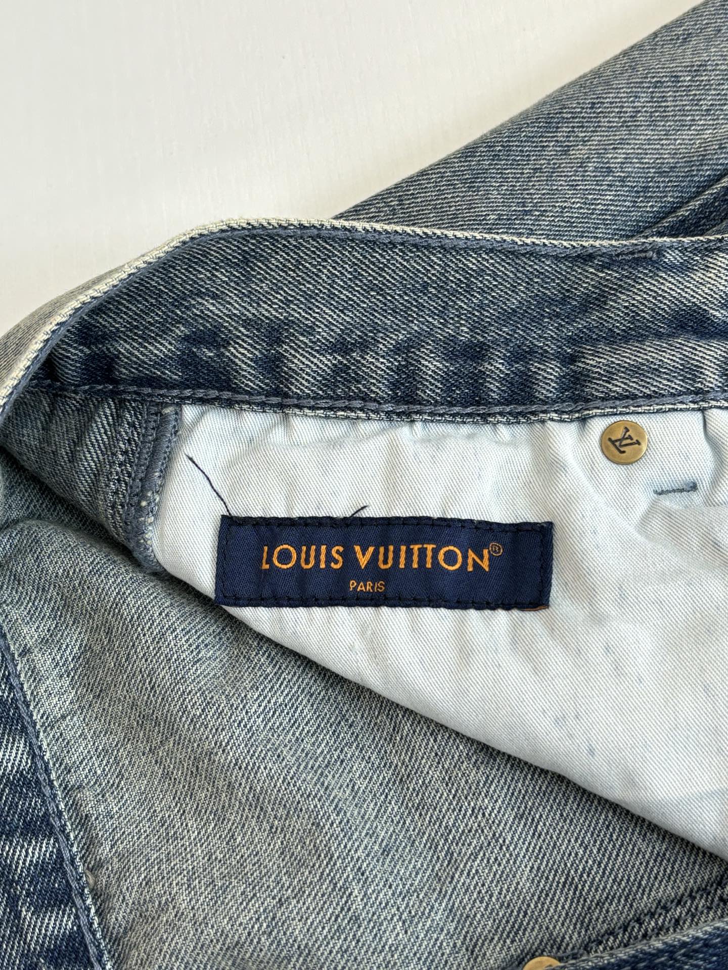 Louis Vuitton denim pants waistband with “LOUIS VUITTON” label and button