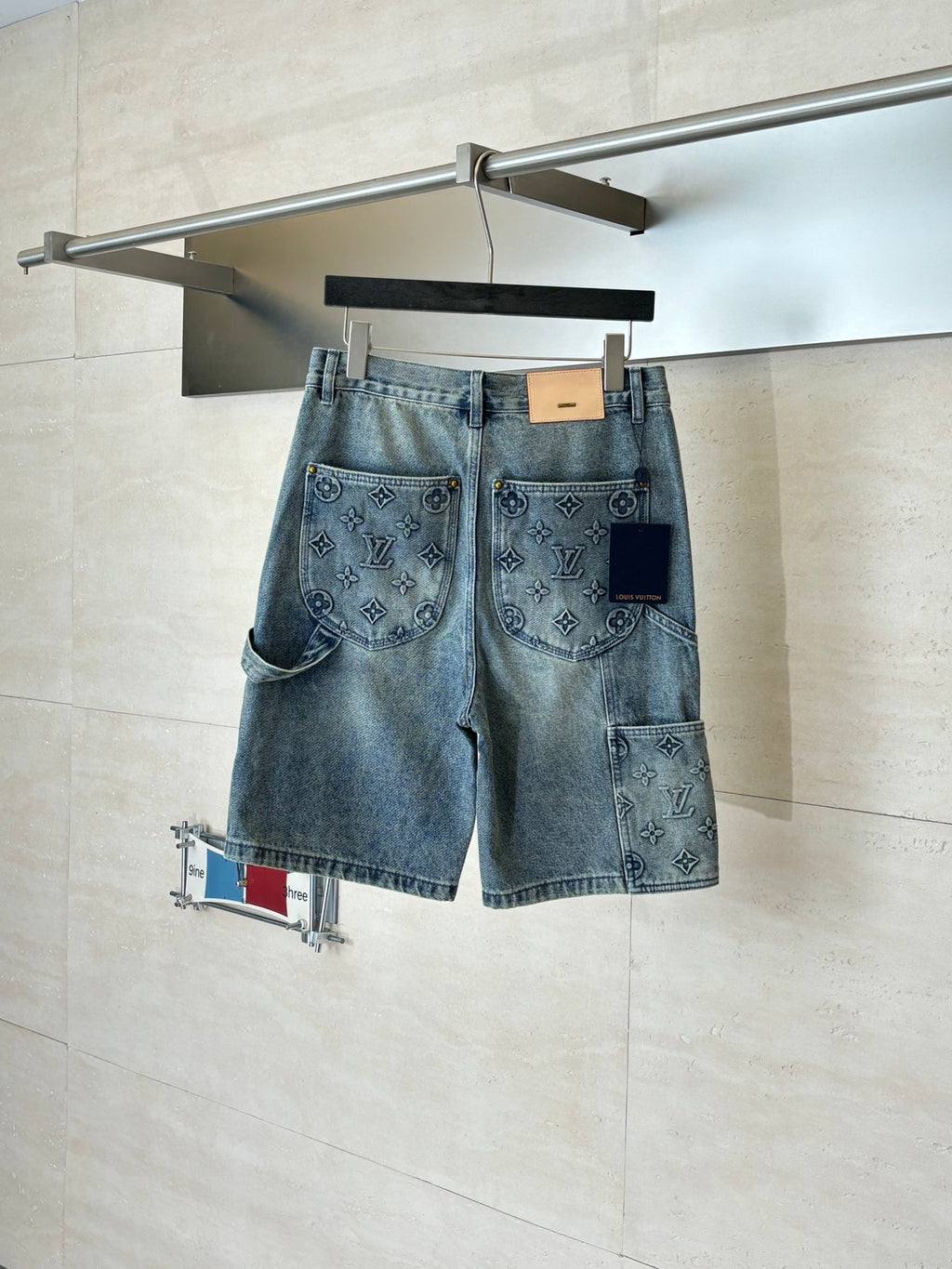 Light blue denim shorts with button fly and monogram-print pocket panels