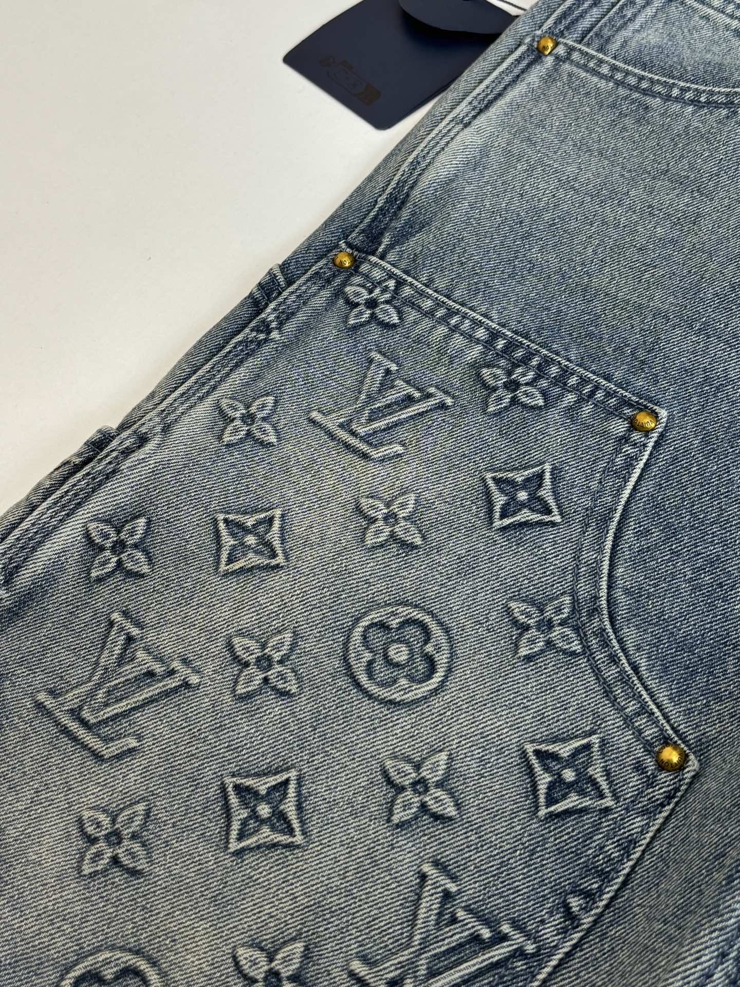 Denim shorts with embossed monogram symbols on the front pocket panel
