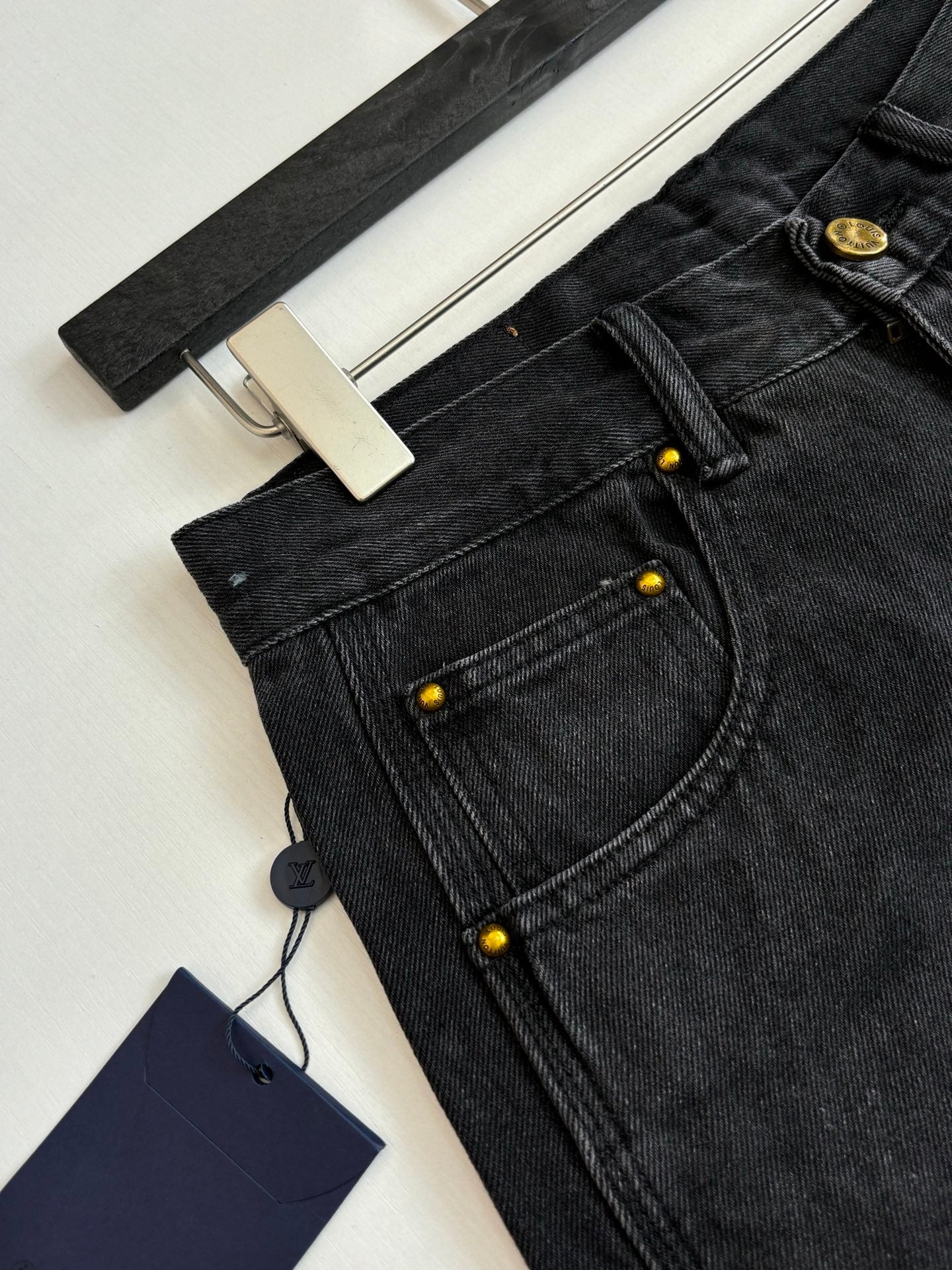Dark denim Louis Vuitton shorts close-up of buttoned pocket and stitched seams