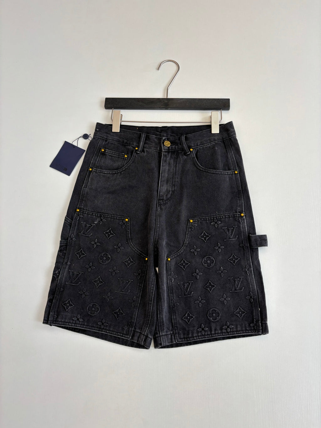 Dark denim Louis Vuitton monogram shorts, laid flat with front closure and pockets