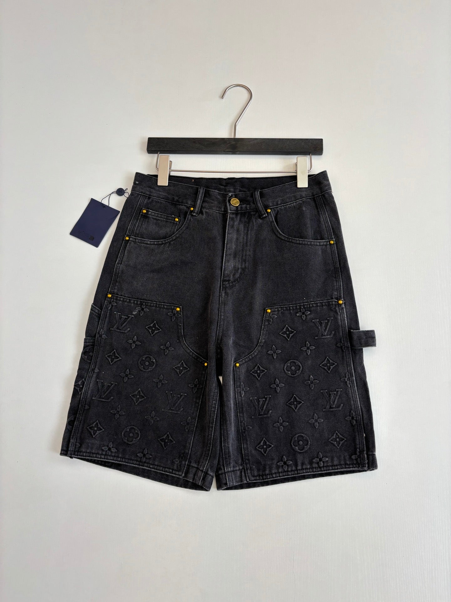 Dark denim Louis Vuitton monogram shorts, laid flat with front closure and pockets