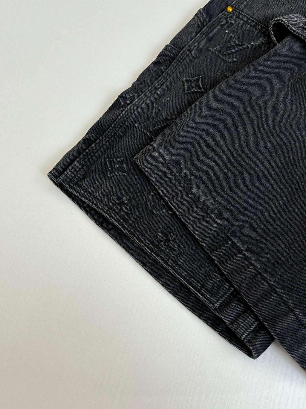 Folded dark denim Louis Vuitton shorts with textured monogram panels